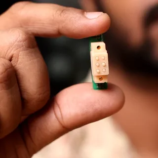 The Braille cell held between finger and thumb.